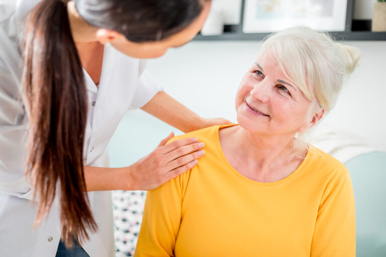 Nurse during home visit talking with senior female and giving treatment advices